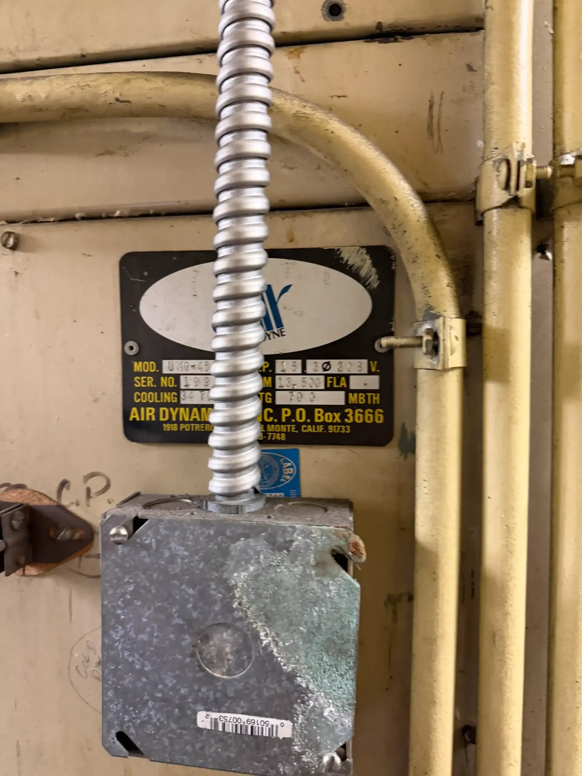 HVAC unit nameplate with electrical junction box and conduit connection