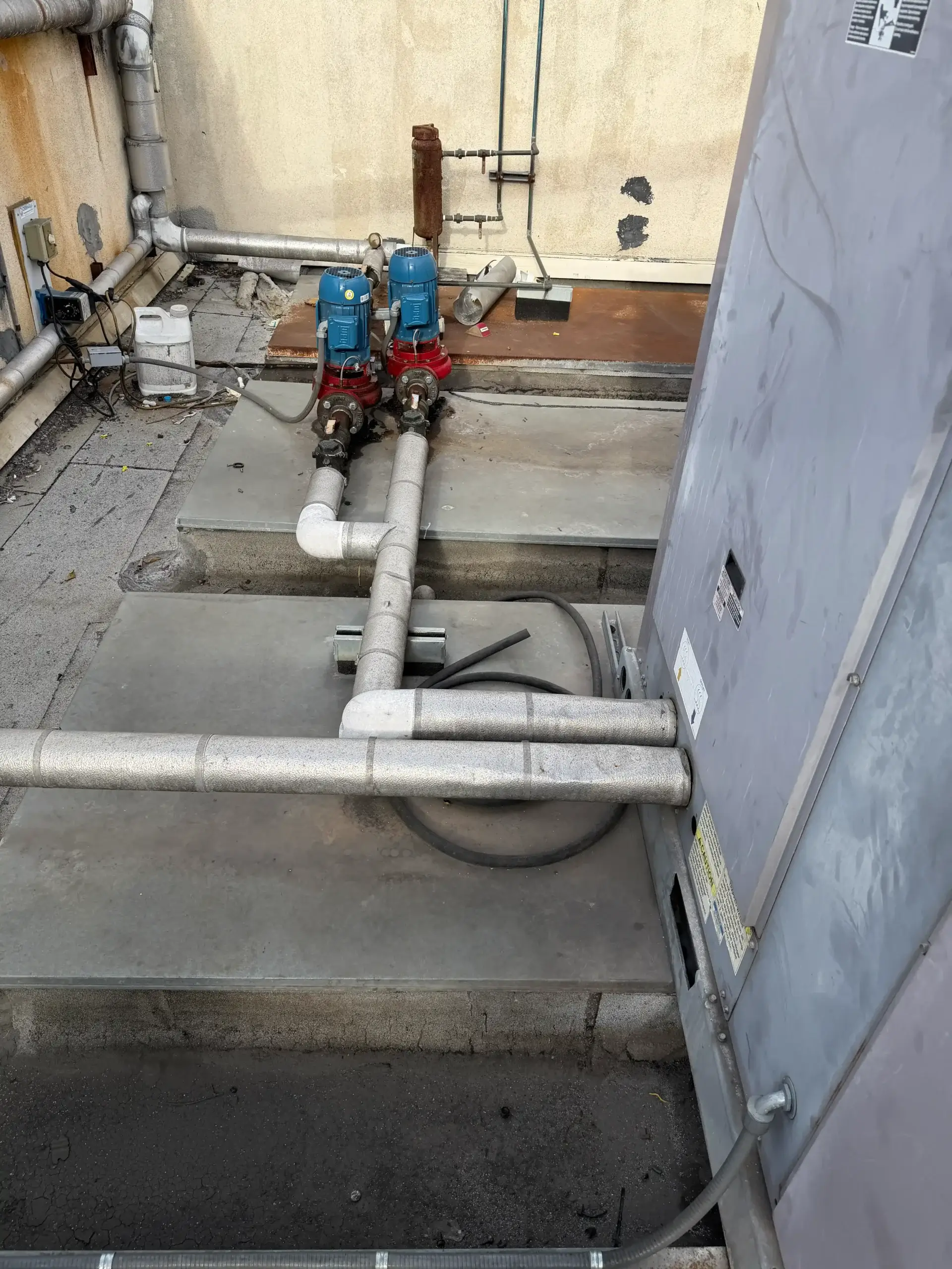 Rooftop HVAC unit with connected piping and dual water pumps